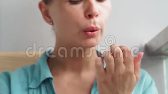 妇吹干钉漆后应用女士在家修剪指甲时烘干指甲油家庭美甲美容视频的预览图