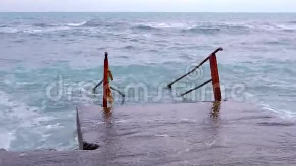 楼梯进入波涛汹涌的大海在海滩上浪荡的糟糕的一天视频的预览图