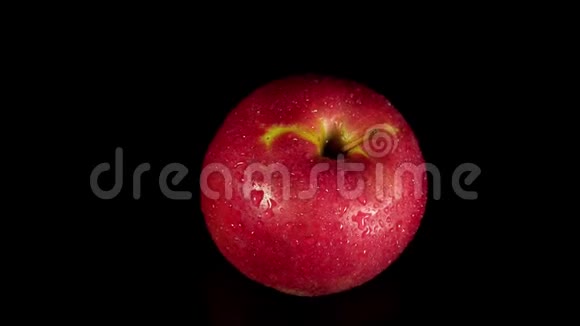 湿红苹果在黑色背景上旋转视频的预览图