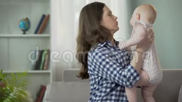 母亲小心翼翼地安慰困倦的婴儿用爱拥抱和亲吻孩子视频的预览图