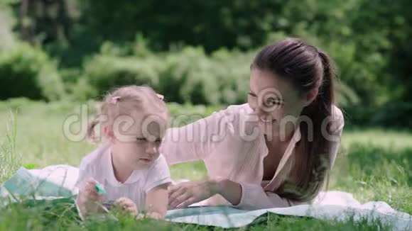 在公园草地上玩耍的母子视频的预览图