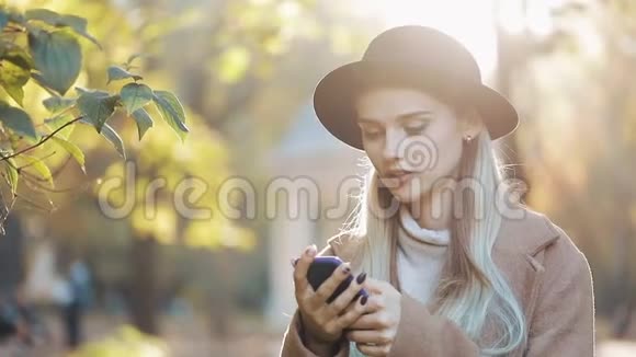 商务女士戴着黑色帽子在户外用手机发送音频语音信息与移动助理交谈女孩使用视频的预览图