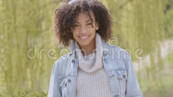 春天或阳光明媚的秋天美丽的混血年轻女子的户外肖像视频的预览图