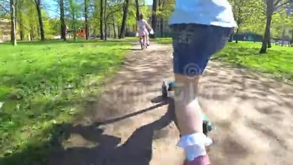 可爱的小女孩骑自行车和摩托车在公园里视频的预览图