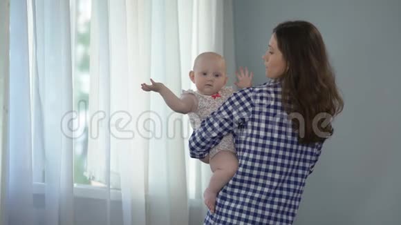 小女孩看着镜头挥动双手慈爱的母亲安慰孩子视频的预览图