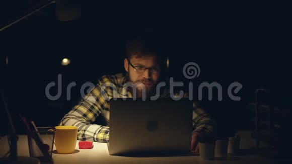 漂亮的办公室工作人员深夜在他的橱柜里辛勤工作喝茶在电脑上编程视频的预览图