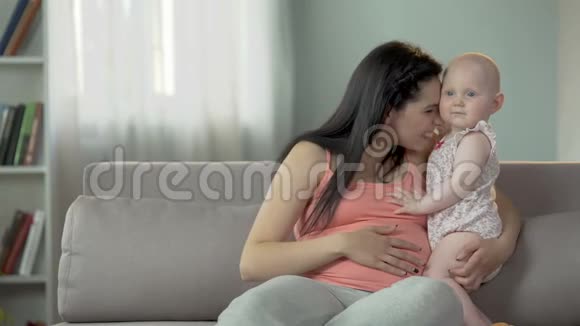 可爱可爱的宝贝女孩拥抱她怀孕的妈妈爱和照顾家庭视频的预览图