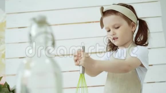 小女孩用玻璃碗搅拌面粉视频的预览图