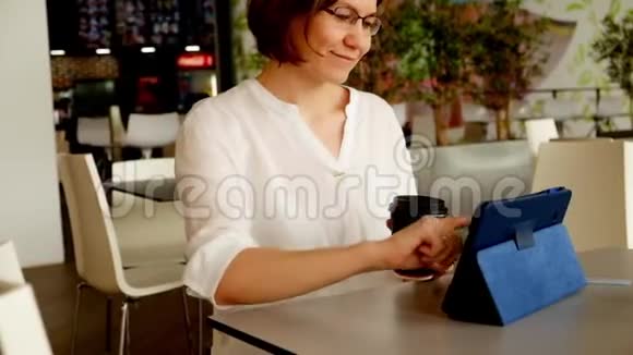 一位在食品法庭工作和喝咖啡的女士视频的预览图