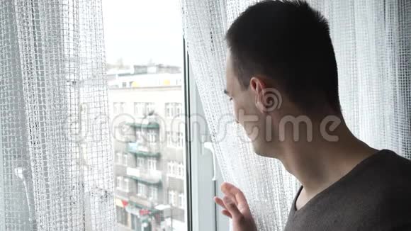 在家等着的男人透过窗户视频的预览图