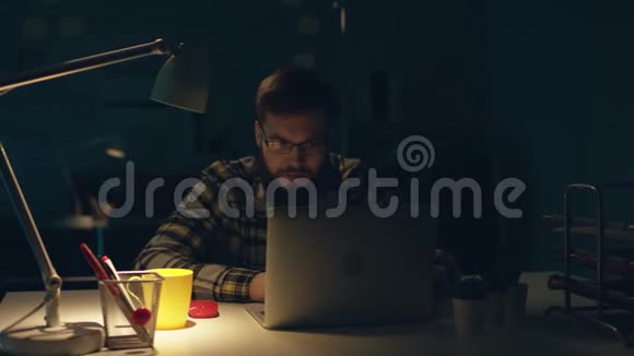 漂亮的办公室工作人员深夜在他的橱柜里辛勤工作喝茶在电脑上编程视频的预览图