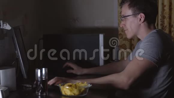 年轻人坐在电脑前吃薯片视频的预览图