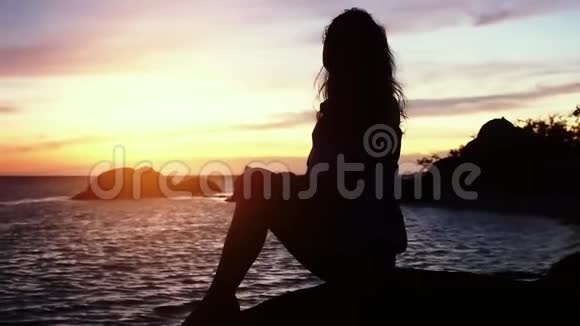 美丽的夕阳下海滩上美丽的梦幻女子望着大海动作缓慢1920x1080视频的预览图