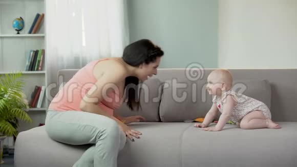 孕妇逗可爱的女婴笑逗孩子玩快乐视频的预览图