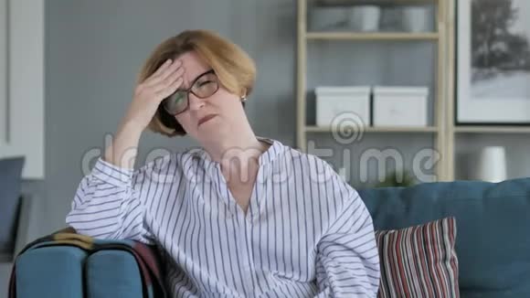 疲惫的老年妇女头痛坐着视频的预览图