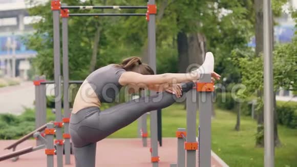 在夏季公园健身训练中做伸展运动的年轻女子视频的预览图