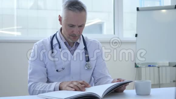 医生在诊所阅读医学书籍视频的预览图