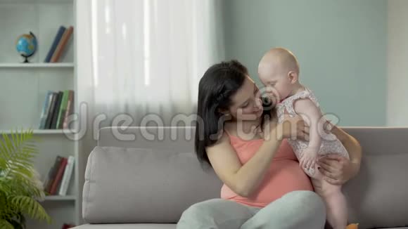 快乐的年轻母亲在第二次怀孕期间享受和孩子在一起的时光视频的预览图