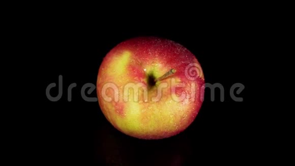 湿红苹果在黑色背景上旋转视频的预览图