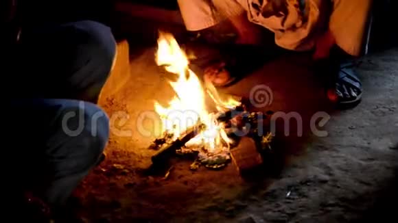 人们围坐在炉火旁取暖在冬季夜景中观看城市景象视频的预览图