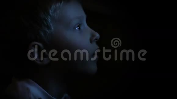 在黑暗中看电视的小男孩视频的预览图