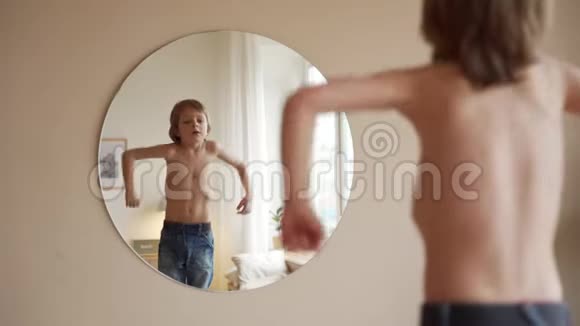 自信的孩子看着镜子里的肌肉想象他是超级英雄视频的预览图