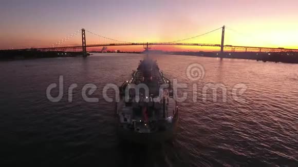 集装箱货运油轮在粉红色日落海景中缓慢航行在壮丽的4k空中无人机视野中视频的预览图