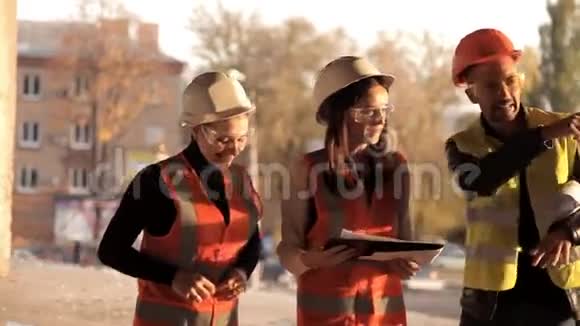 建筑工人和女建筑师们正在观察购物中心新建筑的情况视频的预览图