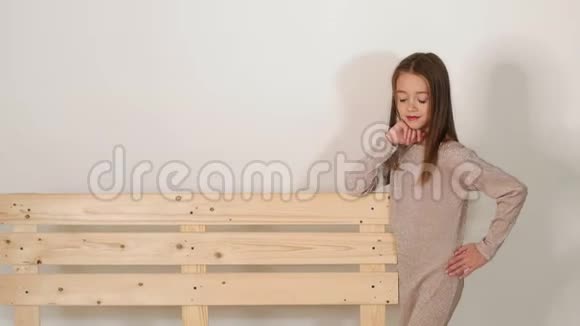 一个小可爱的女孩在工作室靠近一个木制的生态台视频的预览图