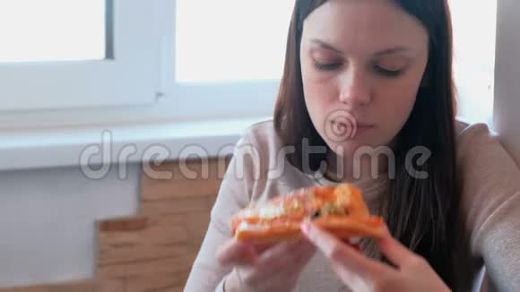 年轻女子正在吃一片自制披萨视频的预览图