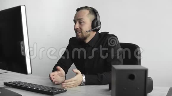 年轻的商人或学生穿着衬衫坐在办公室里的电脑显示器上背景是白色的视频的预览图