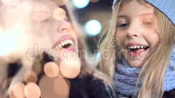 快乐的妈妈和漂亮的小女儿一起享受着烟火般的圣诞假期视频的预览图