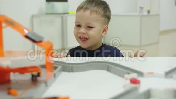 一个小小的有趣的孩子看着机器人展览上克服障碍的蟑螂的微型机器人视频的预览图