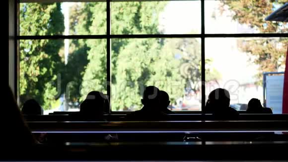 咖啡厅自助餐厅餐饮机构在一扇大窗户的背景上许多黑暗的人的轮廓人口视频的预览图