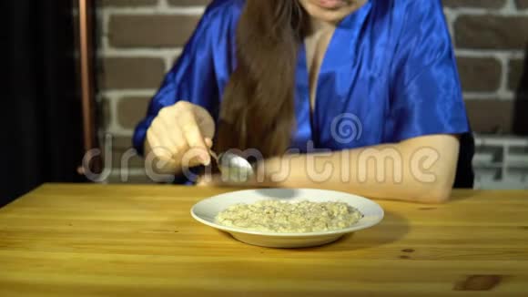 那个女人开着勺子在一盘燕麦片上然后推开粥视频的预览图