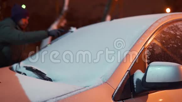 出行前用刮冰机清洗雪边车窗人从车窗上卸下冰男性清洁视频的预览图