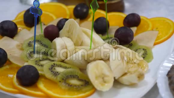 巴奈橘子葡萄奇异果切片特写桌子上有美味的食物节日餐桌上的新鲜水果盘视频的预览图