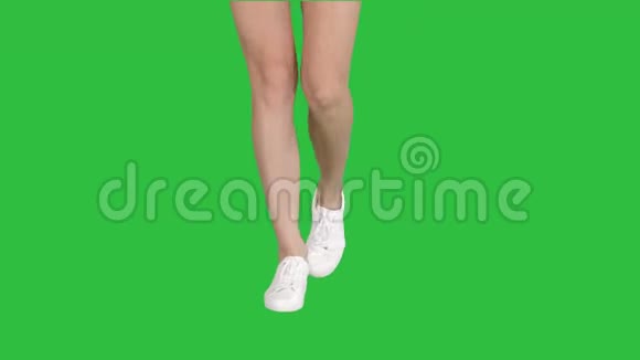 穿着白色运动鞋的女性腿在绿色屏幕上行走Chroma键视频的预览图