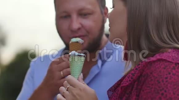 快乐的一对夫妇在夜城散步吃冰淇淋慢动作视频的预览图
