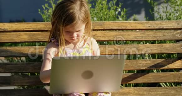 在花园里用笔记本电脑的女孩视频的预览图