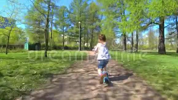 可爱的小女孩骑自行车和摩托车在公园里视频的预览图