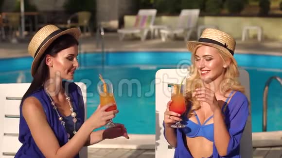 两个女人在泳池边喝鸡尾酒视频的预览图