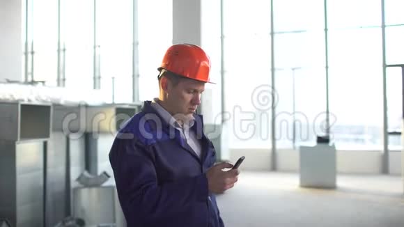 建筑主管建筑工人监督建筑工程并与对讲机交谈在一个视频的预览图