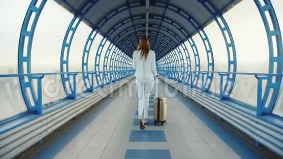 后景穿白色西装的时尚商务女性穿过隧道或从玻璃上过渡视频的预览图