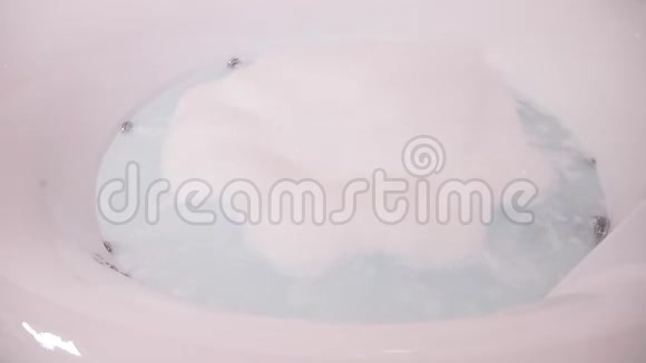 一个现代圆形浴缸配有按摩浴缸里面充满了泡沫肥皂泡沫的鼓泡水里面没有人4k慢动作视频的预览图