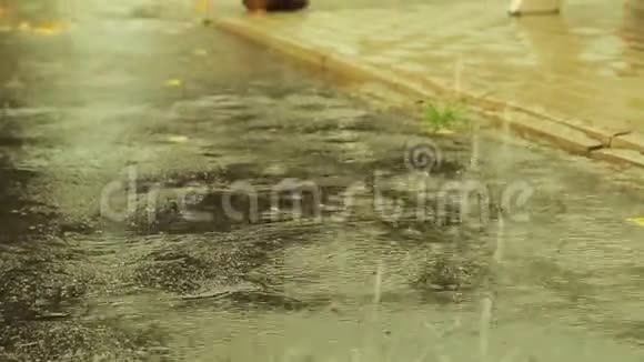 大的雨滴落在浇水的沥青路上视频的预览图