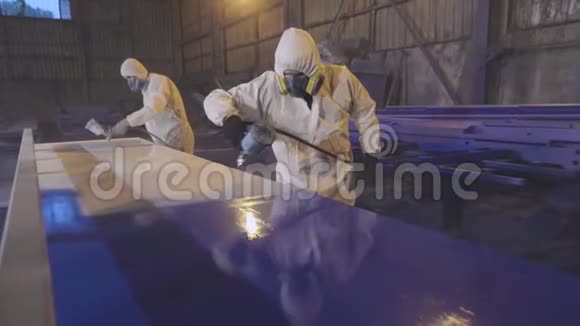 男人用蓝色画一个大细节在工厂画画油漆大部件视频的预览图
