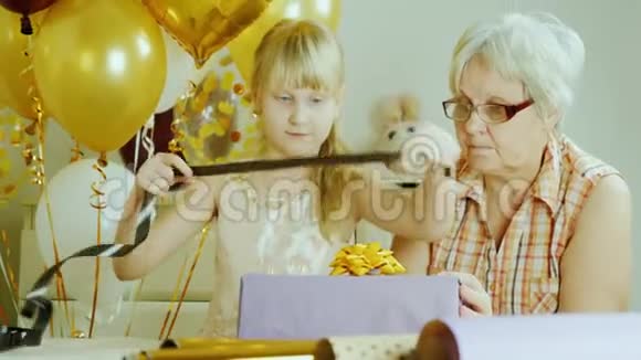 祖母和孙女一起打包礼物积极的老年人概念视频的预览图
