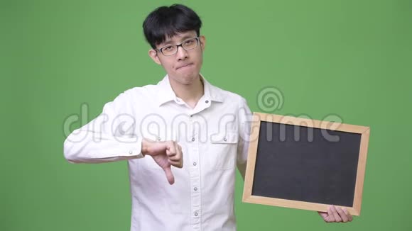 年轻的亚洲商人一边举着黑板一边竖起大拇指视频的预览图