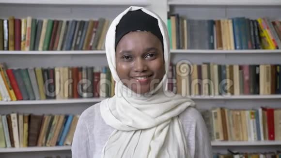 戴头巾的年轻迷人的非洲穆斯林女孩正在镜头前观看relieioun概念背景书视频的预览图